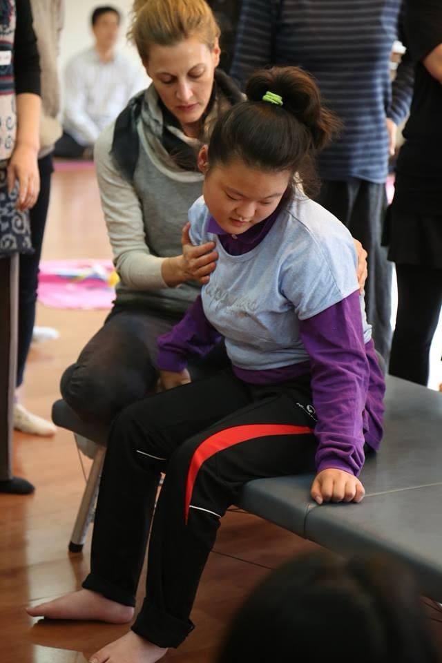 Naomi working with a young student during a group workshop